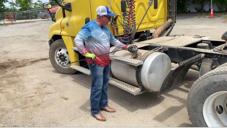 Side of semi truck cab with instructor pointing