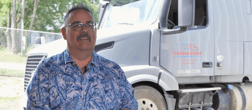 Covenant recruiter standing in front of semi truck, smiling