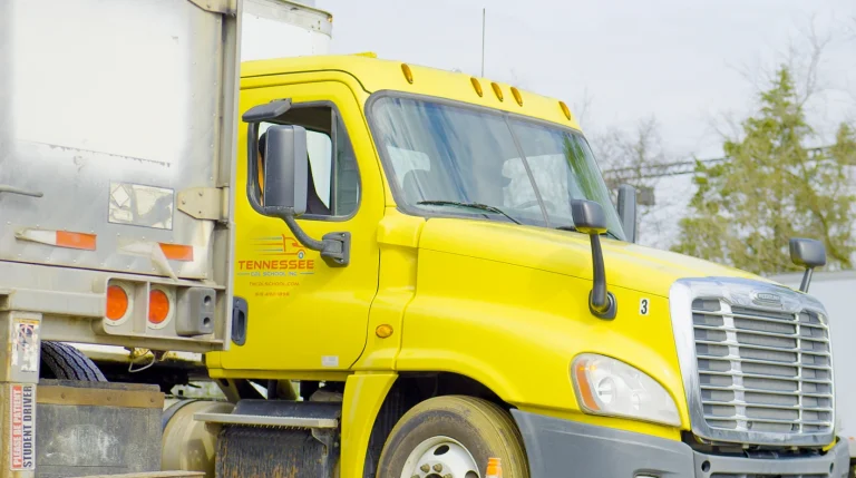 Front view of yellow Tennessee CDL School semi truck cab